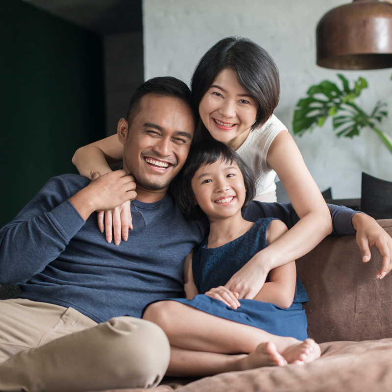 family smiling sitting on couch