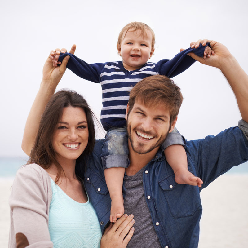 family smiling on a beach